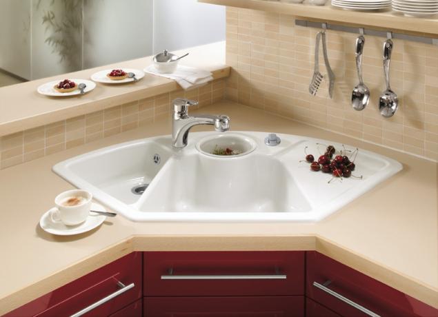 Снимката показва ъглова кухненска мивка с три купи и отцедник.