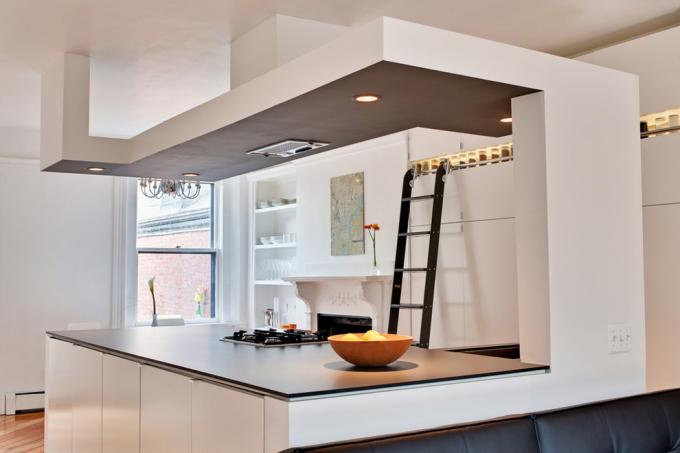 Преходите от гипсокартон, както е на снимката, често се използват за подобряване на зонирането в кухните, комбинирани с други стаи